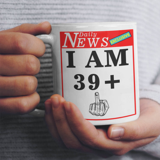 Mug with a humorous design featuring 'I AM 39+' and a middle finger gesture, held by hands.