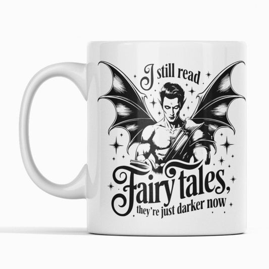 White mug black print. winged beast. Text I still read fairy tales, they're just darker now. 
