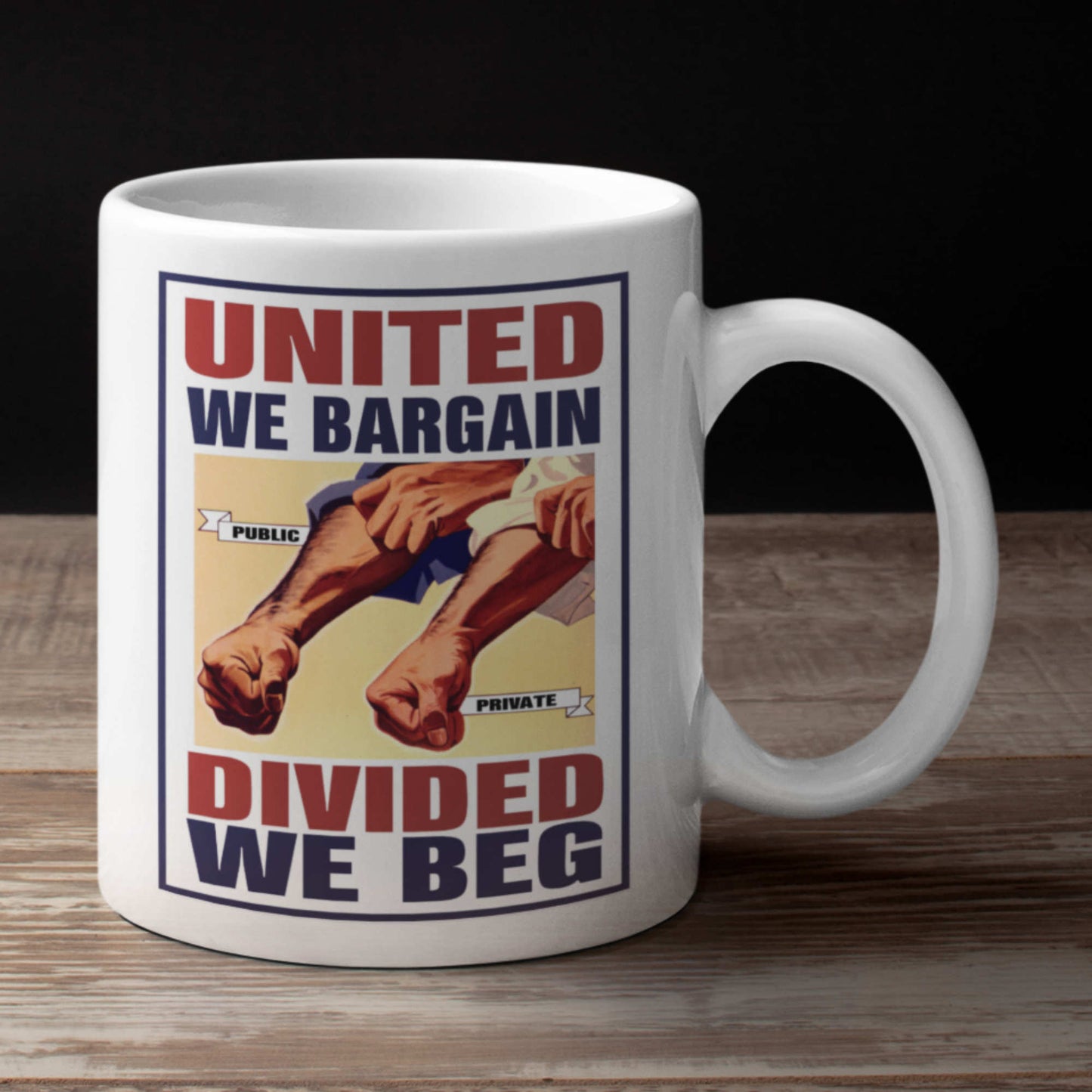 Mug with graphic design of hands and text 'United We Bargain, Divided We Beg' on a wooden surface.