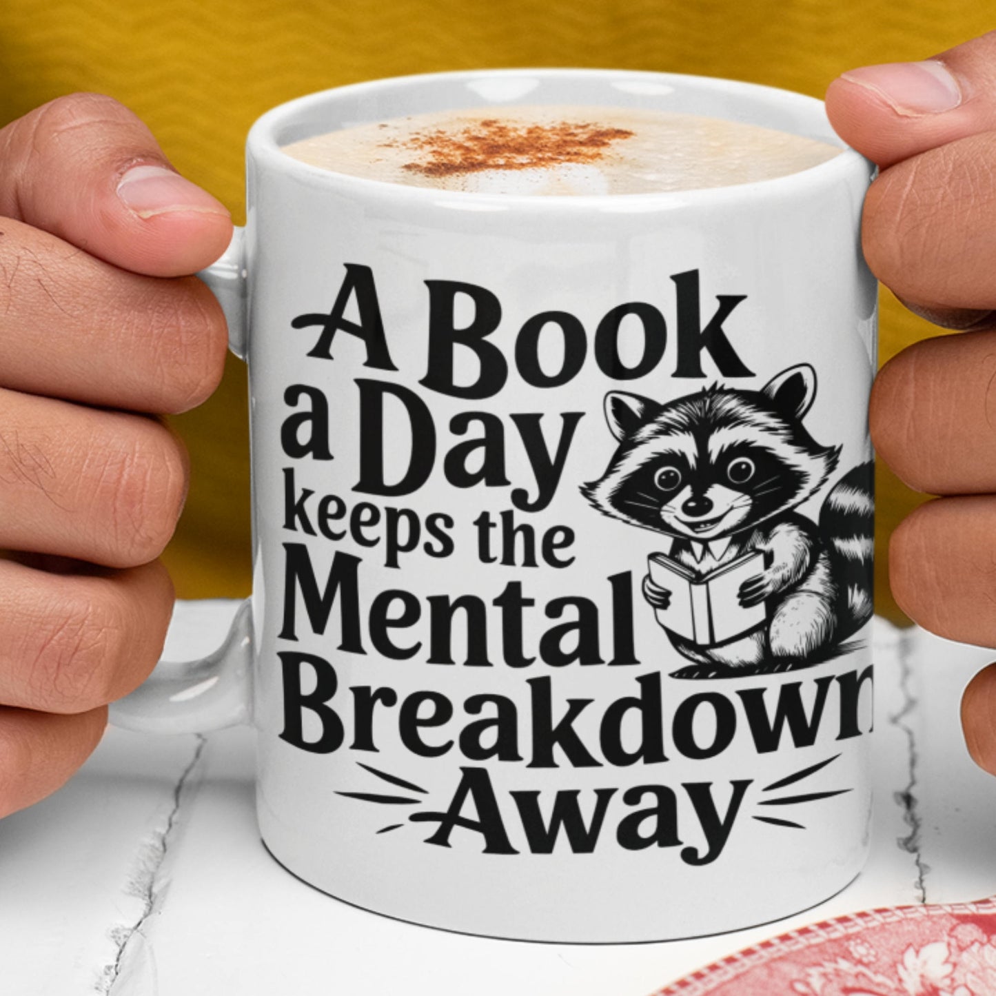 White mug a mug a day keeps mental breakdown away with racoon in hands.