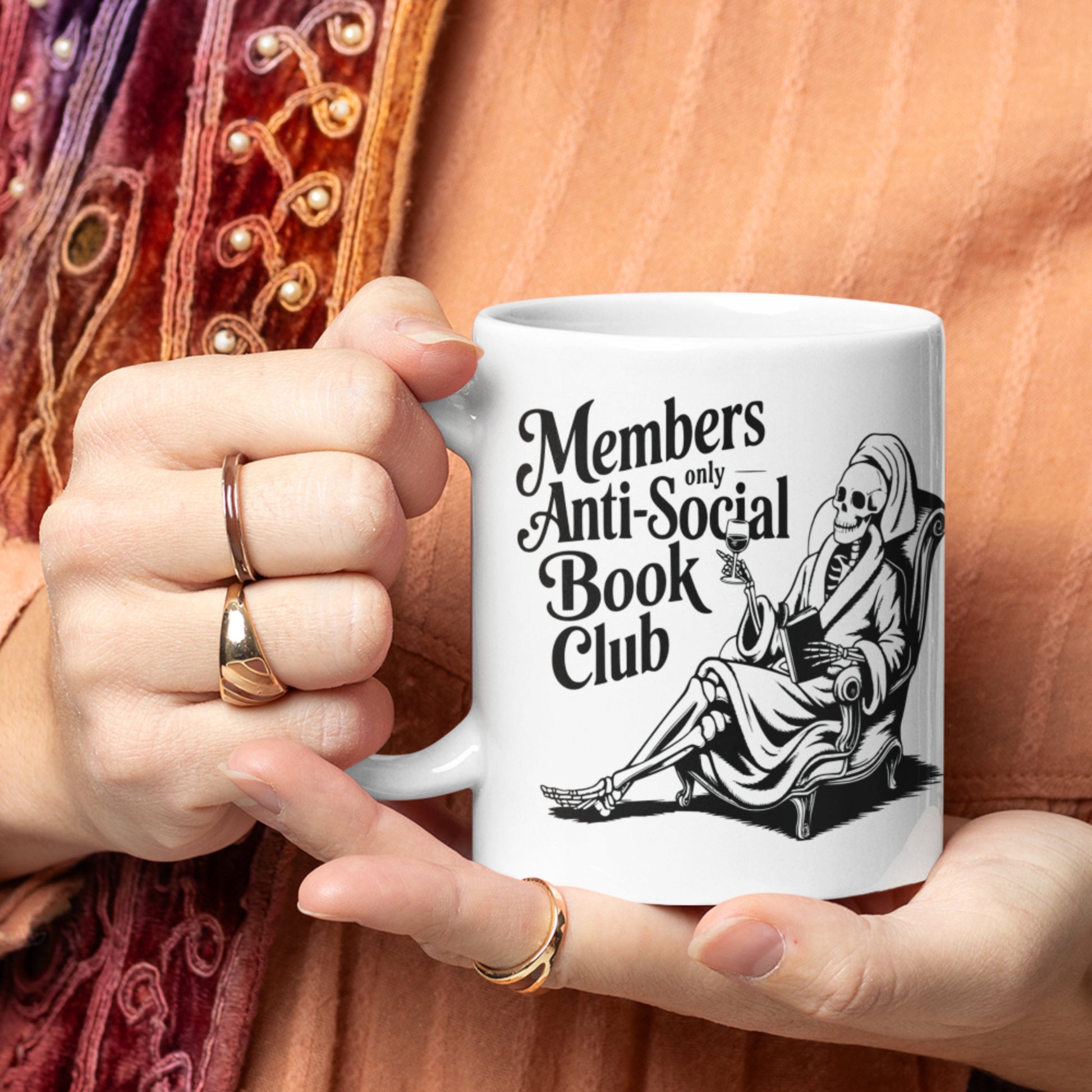 Members only antisocial book club with a skeleton white mug handheld.