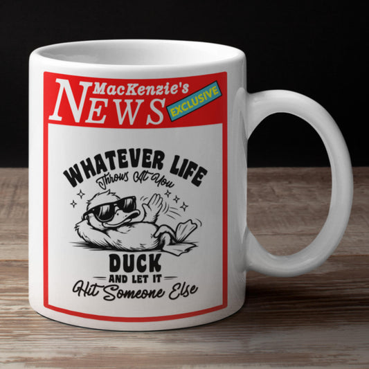White mug with a humorous design featuring a duck and text on a wooden surface.